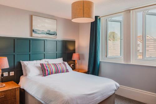 尚克林Gracellie Hotel的一间卧室设有一张大床和两个窗户。