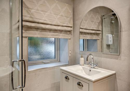 Shotley BridgeHoney Hirst的一间带水槽和镜子的浴室以及窗户。