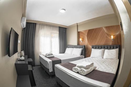 伯萨Loyal City The Best Hotel in Bursa的酒店客房,设有两张床和镜子