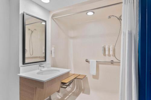 奥兰多Spark by Hilton Orlando near SeaWorld的白色的浴室设有水槽和淋浴。