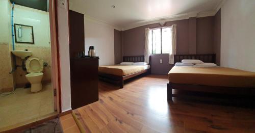 伯恩仓Hotel Sentosa的客房设有两张床、一个卫生间和窗户。