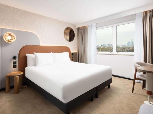 伦敦Mercure London Earls Court的一间设有大床和窗户的酒店客房