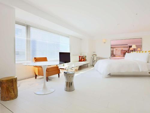 台北台北敦化美憬阁酒店的白色卧室配有一张大床和一张书桌