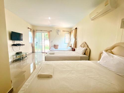 พายเนอรี รีสอร์ท @แหล่มแท่น (Pinery Resort)的酒店客房设有两张床和电视。