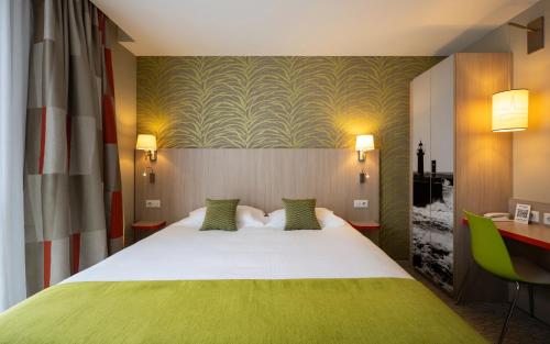 圣马洛圣马洛基里亚德普雷斯蒂奇酒店的配有一张床和一张书桌的酒店客房