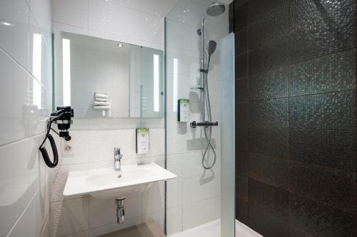 圣马洛圣马洛基里亚德普雷斯蒂奇酒店的白色的浴室设有水槽和淋浴。
