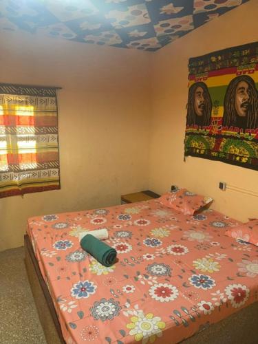 NdanganeKEUR Junior的一间卧室配有一张带粉红色棉被的床