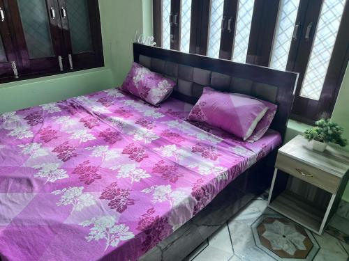 AyodhyaAKG Home Stays的一张带粉红色棉被和枕头的床
