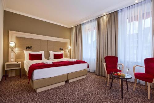 苏黎世圣哥特哈尔德酒店的酒店客房带大床和红色椅子
