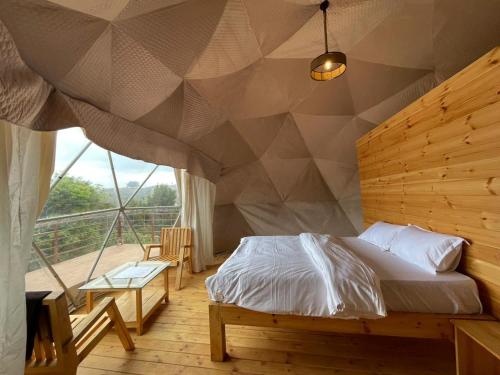 科代卡纳尔L.T NATURE GLAMPS的一间卧室配有一张几何墙床
