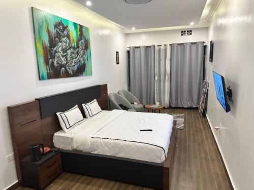 鲁亨盖里Ruhondo Beach Resort的卧室配有一张床,墙上挂有绘画作品