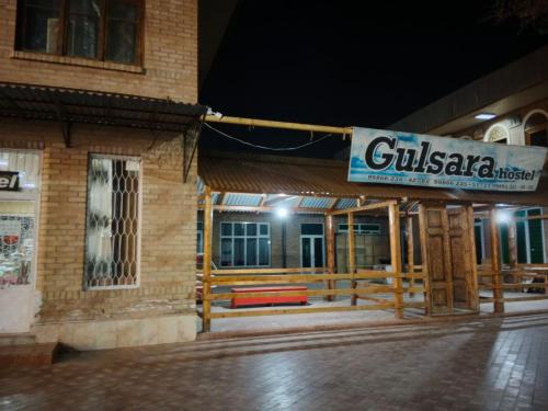 撒马尔罕Hostel Gulsara的夜间建筑物一侧的标志