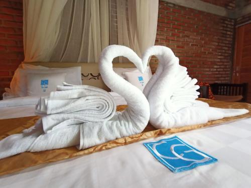 KubutambahanCoco Garden Pool Villas的床上的两条天鹅绒毛巾