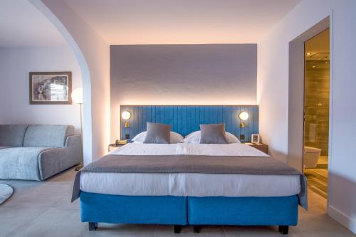 布里萨戈Suiten-Hotel Sunstar Brissago的一间卧室配有蓝色的床和沙发