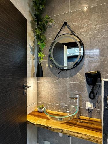 科托努Klik Klak Appart Hotel的一间带玻璃水槽和镜子的浴室