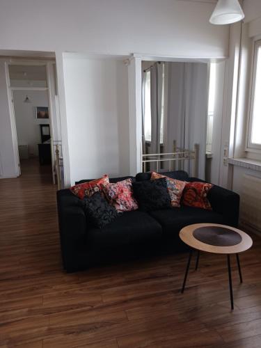 于韦斯屈莱Anne's City Apartment的客厅配有黑色沙发和桌子