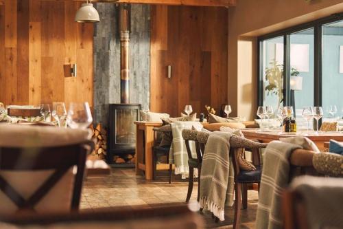 廷塔杰尔威廉港酒店的一间带壁炉和桌椅的用餐室