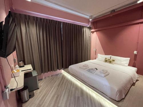 曼谷The Palette Bangkok Hotel的一间卧室配有一张大床和两条毛巾