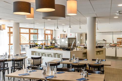 OzVillages Clubs du Soleil - OZ EN OISANS的一间带桌椅的餐厅和一间厨房