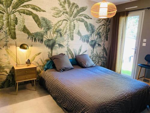 Chatuzange-le-GoubetLe Saint Marin的一间卧室配有一张带热带壁纸的床