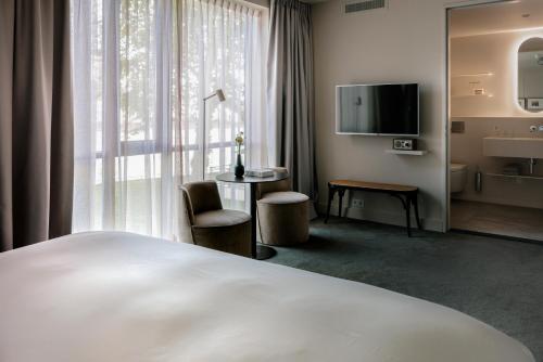 迪温特Pillows Luxury Boutique Hotel aan de IJssel的酒店客房设有一张床和一个大窗户