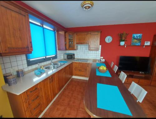 洛斯·亚诺斯·德·阿里丹Vivienda Vacacional Noni, Los Llanos de Aridane的厨房设有蓝色台面和红色墙壁