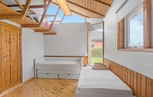 Bogø ByNice Home In Bog By With Wifi的一间卧室设有两张床和窗户。