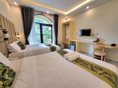 贡布Hang Meas Boutique的酒店客房设有三张床和电视。