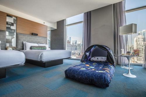 芝加哥Aloft Chicago Downtown River North的酒店客房,设有两张床和一辆婴儿车