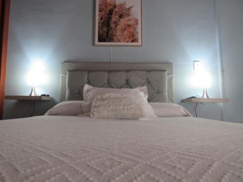 麦德林Apartamento Rincon sereno的卧室配有带两盏灯的白色床