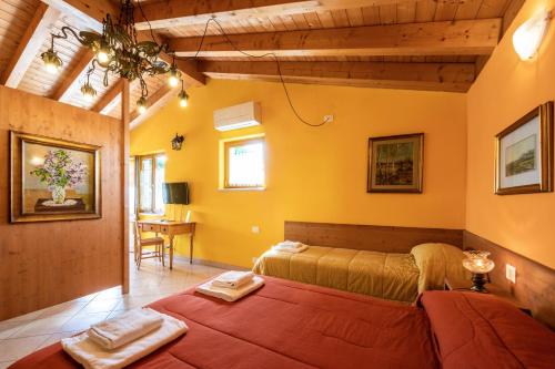 Quinto di ValpantenaAgriturismo il Porcellino的一间设有两张床的卧室,位于拥有黄色墙壁的房间