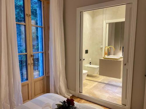 毕尔巴鄂Monappart Cristo Historic Apartment with Parking的一间卧室,带卫生间的浴室和窗户