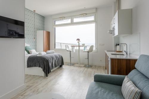 吉塔里亚APARTAMENTOS KRESALA - Vistas al mar的一间卧室配有一张床,厨房配有窗户