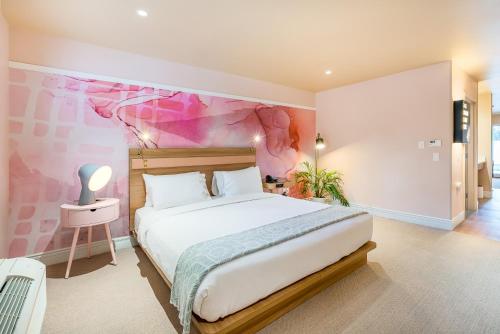 南安普敦南安普敦宾利酒店的一间卧室配有一张带粉红色墙壁的大床