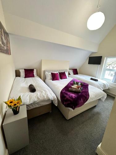 利物浦Elm Vale Lodge的紫色枕头间内的两张床