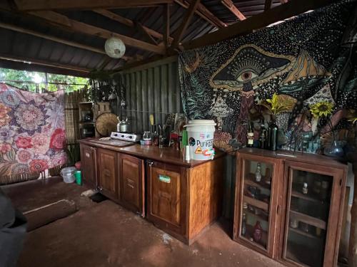 金贾Jinja Jungle的厨房配有木制橱柜和带壁画的墙壁