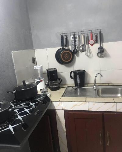 雅温得Studio - Yaoundé - Bastos的厨房配有带锅碗瓢盆的炉灶。