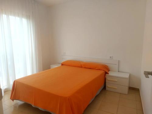 坎布里尔斯Rentalmar Playmar的一间卧室配有一张带橙色毯子的床