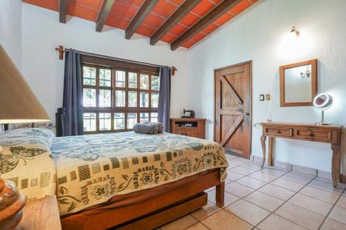 瓦兹特佩克Amazing family house in Oaxtepec Pool & Hot tub的一间卧室配有一张床、一张书桌和一个窗户。