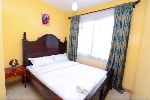 内罗毕The Perfect New Nest的一间卧室设有一张大床和一个窗户。