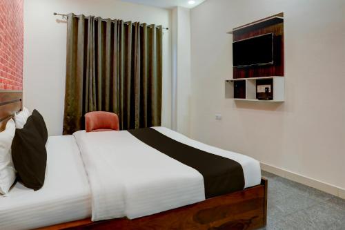 勒克瑙HOTEL AASTHA SHREE DHAM的酒店客房,配有床和电视