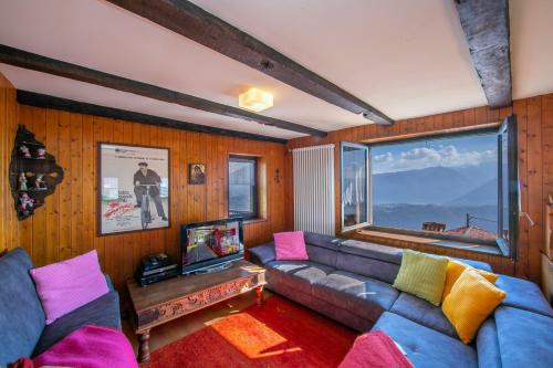 卡迪马里奥Chalet Cademario - Happy Rentals的带沙发和大窗户的客厅