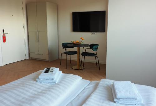 博克斯梅尔特菲尔特里克酒店的客房设有一张床和一张桌子及电视