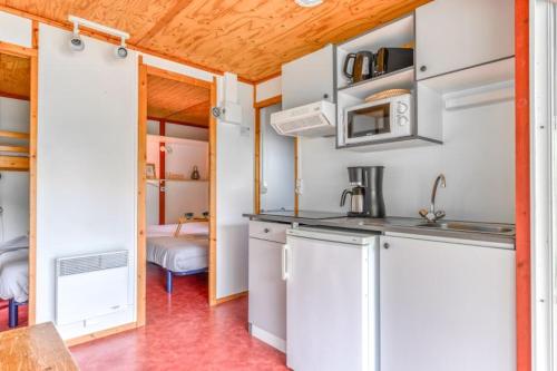 Aigues-VivesCamping LA SERRE的一间厨房,内设白色橱柜和水槽