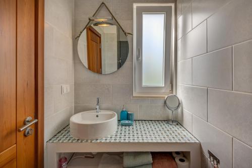 西尔韦斯Quinta das Piteiras Turismo Rural的一间带水槽和镜子的浴室