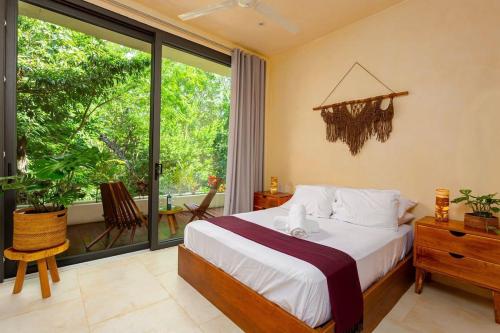 艾库玛尔* Dream Villa on Private Cenote 10min to Beach的一间卧室设有一张床和一个大窗户