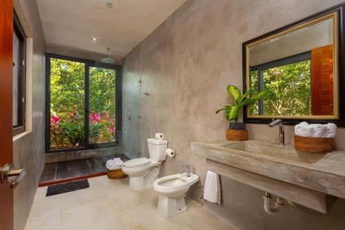 艾库玛尔* Dream Villa on Private Cenote 10min to Beach的浴室设有2个卫生间、水槽和镜子
