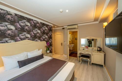 伊斯坦布尔雷蒙德酒店的一间卧室配有一张壁画床