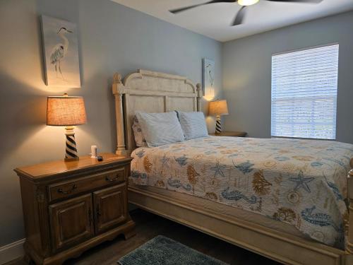 博尼塔斯普林斯Redfish - Updated & Roomy 1.5 Mi to Beach Full Kitchen W&D的一间卧室配有一张床和一个带灯的床头柜