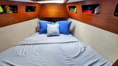 Puerto LindoVelero en Isla Linton的小卧室配有带蓝色枕头的床